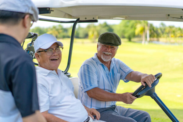 Friends laughing together while playing golf.