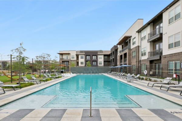 Pool deckwith greenspace in apartment complex